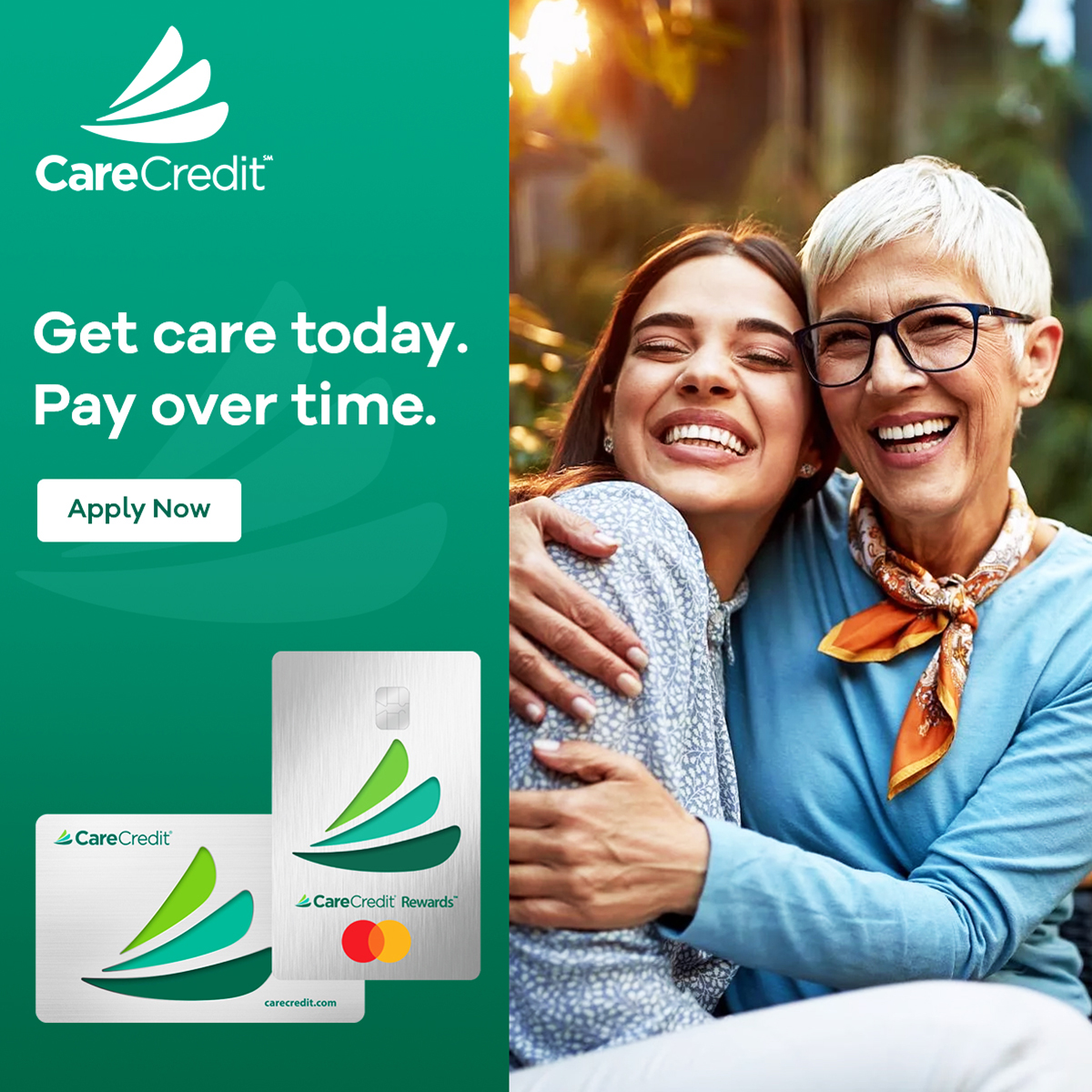 Two smiling women embracing outdoors with CareCredit payment cards and dental financing messaging displayed.